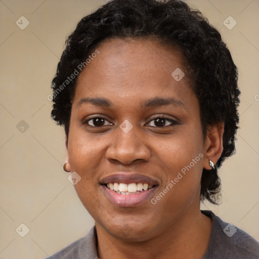 Joyful black young-adult female with short  black hair and brown eyes