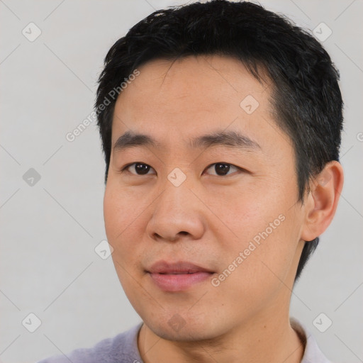 Joyful asian young-adult male with short  black hair and brown eyes