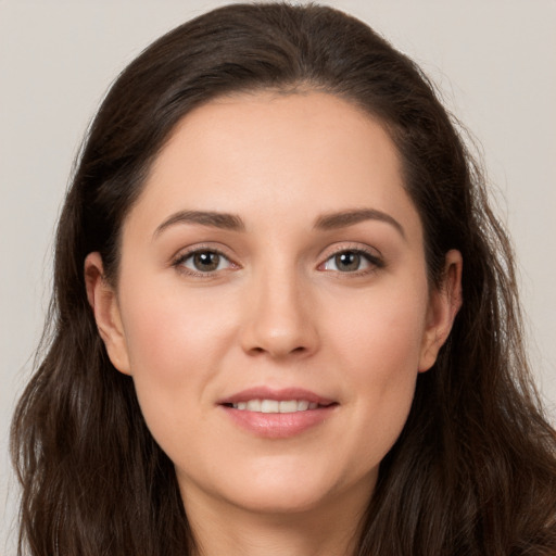 Joyful white young-adult female with long  brown hair and brown eyes