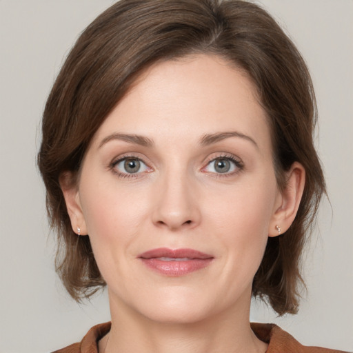 Joyful white young-adult female with medium  brown hair and grey eyes