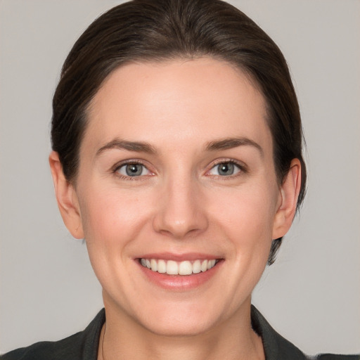 Joyful white young-adult female with short  brown hair and grey eyes