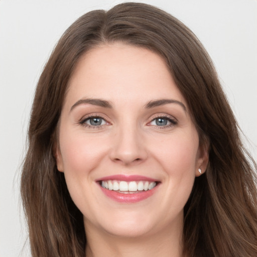 Joyful white young-adult female with long  brown hair and grey eyes