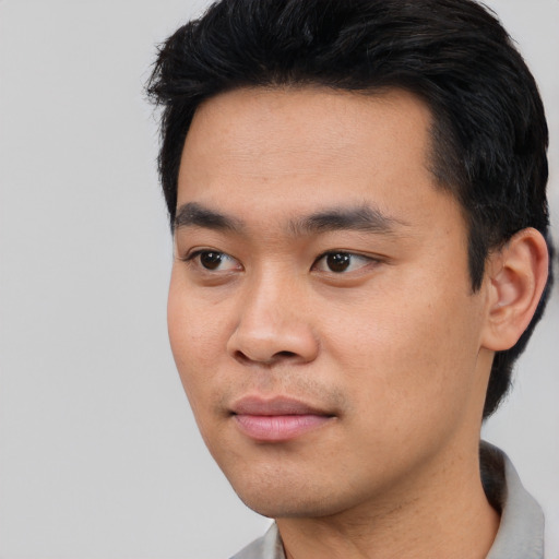 Joyful asian young-adult male with short  black hair and brown eyes