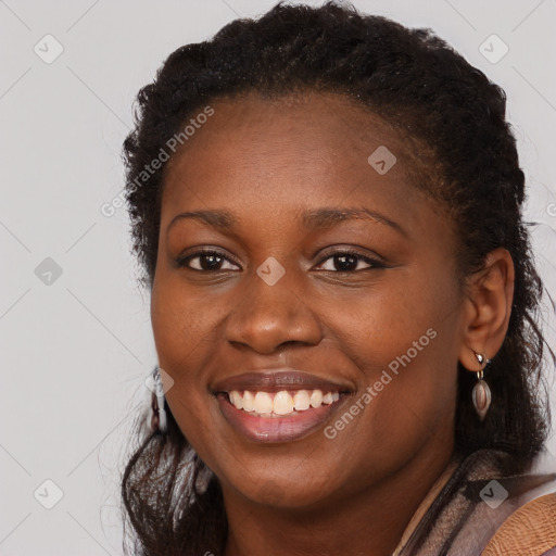 Joyful black young-adult female with long  brown hair and brown eyes