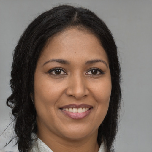 Joyful black young-adult female with long  brown hair and brown eyes
