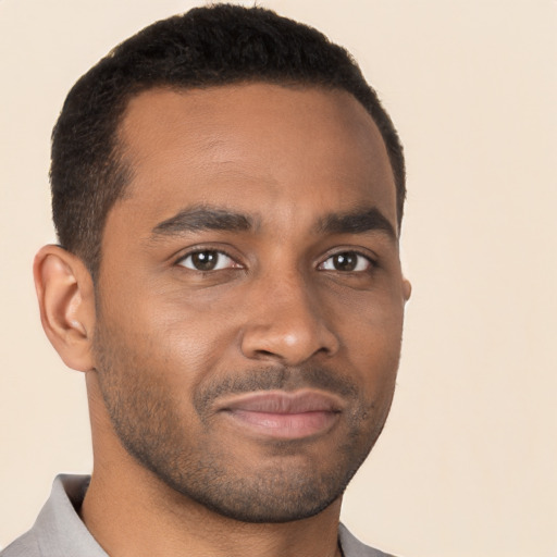 Joyful black young-adult male with short  brown hair and brown eyes