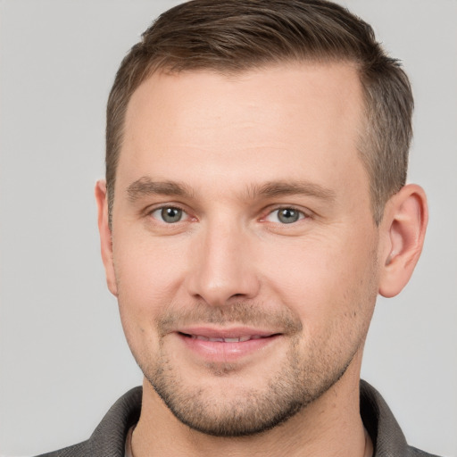 Joyful white young-adult male with short  brown hair and grey eyes