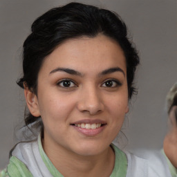 Joyful latino young-adult female with medium  brown hair and brown eyes