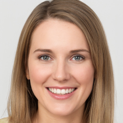 Joyful white young-adult female with long  brown hair and grey eyes