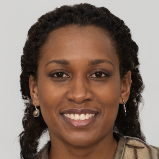 Joyful black adult female with long  brown hair and brown eyes