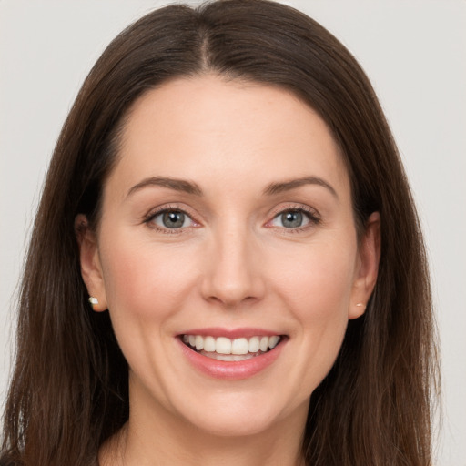 Joyful white young-adult female with long  brown hair and grey eyes