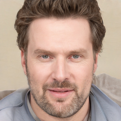 Joyful white adult male with short  brown hair and grey eyes