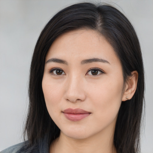Joyful asian young-adult female with long  brown hair and brown eyes