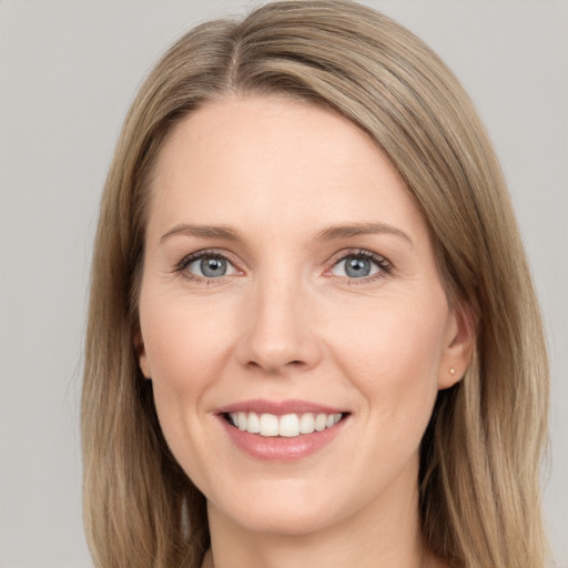 Joyful white young-adult female with long  brown hair and grey eyes