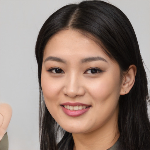 Joyful asian young-adult female with long  black hair and brown eyes