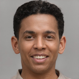 Joyful latino young-adult male with short  brown hair and brown eyes