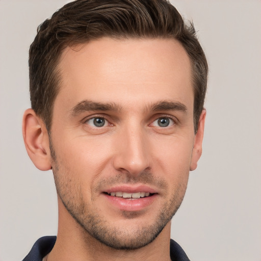 Joyful white young-adult male with short  brown hair and grey eyes