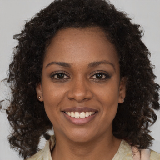 Joyful black young-adult female with medium  brown hair and brown eyes