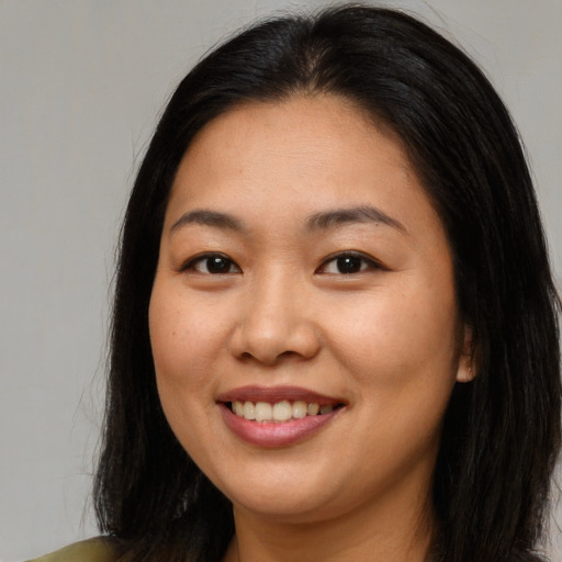 Joyful asian young-adult female with long  brown hair and brown eyes