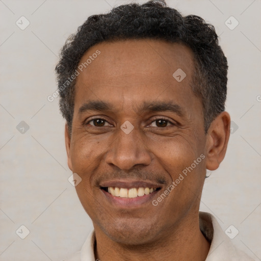 Joyful black adult male with short  brown hair and brown eyes