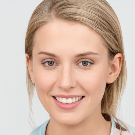 Joyful white young-adult female with medium  brown hair and blue eyes