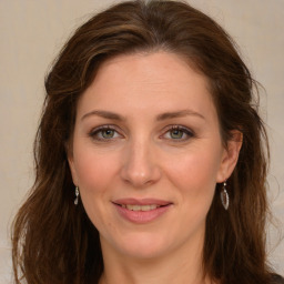 Joyful white young-adult female with long  brown hair and green eyes