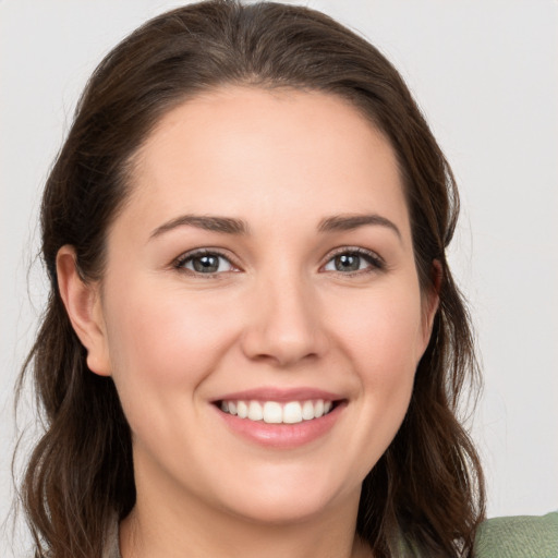 Joyful white young-adult female with long  brown hair and grey eyes