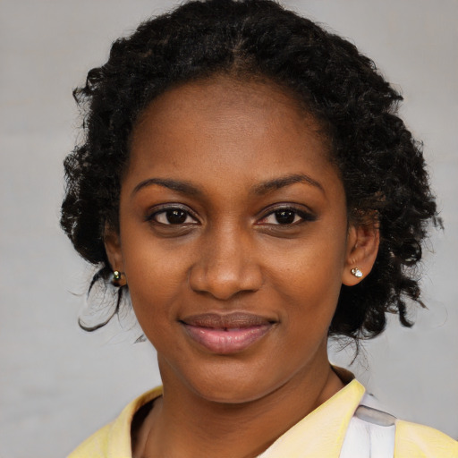 Joyful black young-adult female with medium  black hair and brown eyes