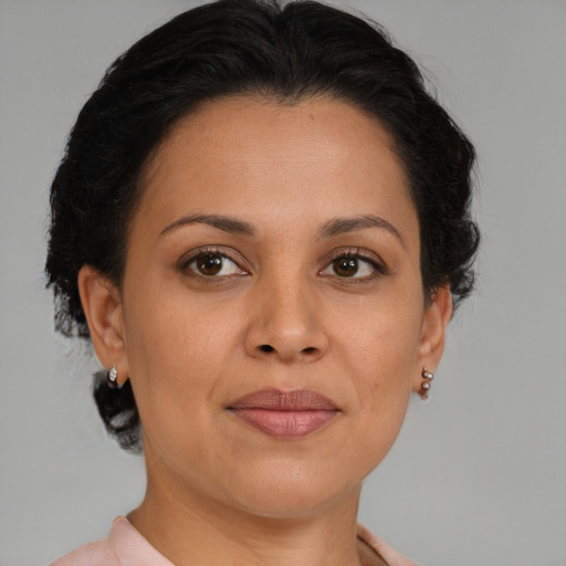 Joyful latino adult female with medium  brown hair and brown eyes