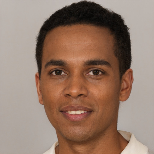 Joyful black young-adult male with short  brown hair and brown eyes