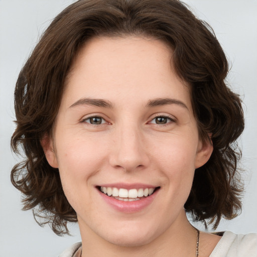 Joyful white young-adult female with medium  brown hair and green eyes