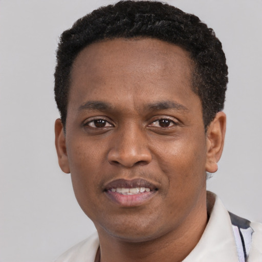 Joyful black young-adult male with short  black hair and brown eyes