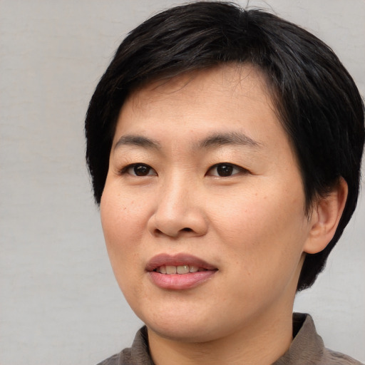 Joyful asian young-adult female with short  black hair and brown eyes