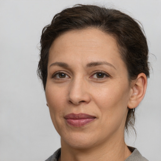 Joyful white adult female with medium  brown hair and brown eyes