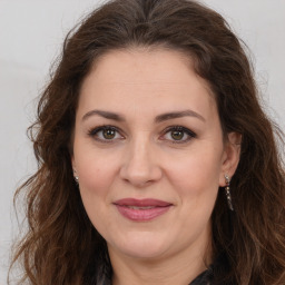 Joyful white adult female with long  brown hair and brown eyes