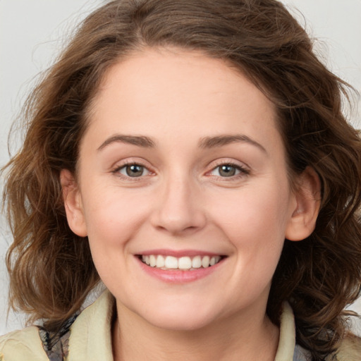 Joyful white young-adult female with long  brown hair and green eyes