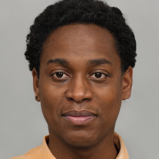 Joyful black young-adult male with short  black hair and brown eyes