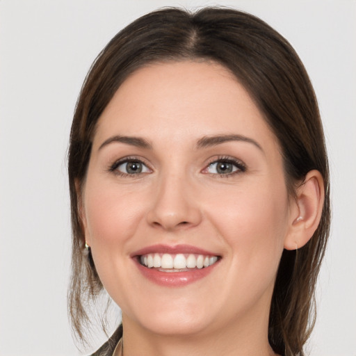 Joyful white young-adult female with medium  brown hair and grey eyes