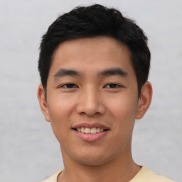 Joyful asian young-adult male with short  black hair and brown eyes