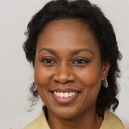 Joyful black adult female with long  brown hair and brown eyes