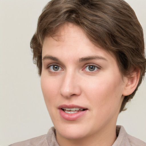 Joyful white young-adult female with short  brown hair and grey eyes