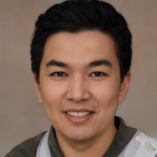 Joyful white young-adult male with short  black hair and brown eyes