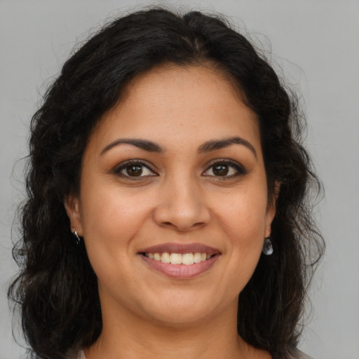 Joyful latino young-adult female with long  brown hair and brown eyes