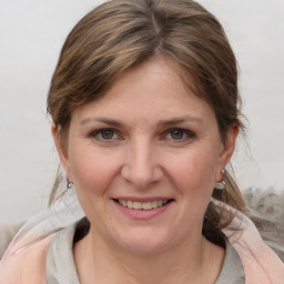 Joyful white young-adult female with medium  brown hair and grey eyes