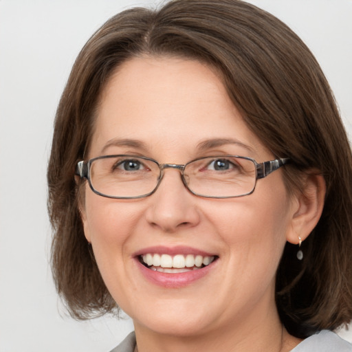 Joyful white adult female with medium  brown hair and grey eyes