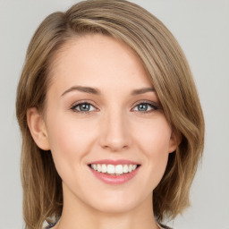 Joyful white young-adult female with long  brown hair and green eyes