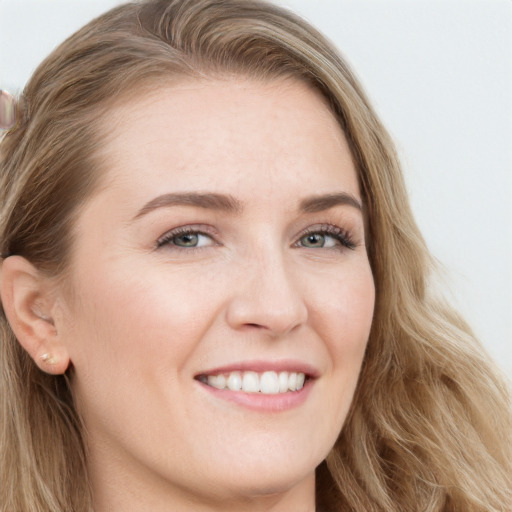 Joyful white young-adult female with long  brown hair and blue eyes