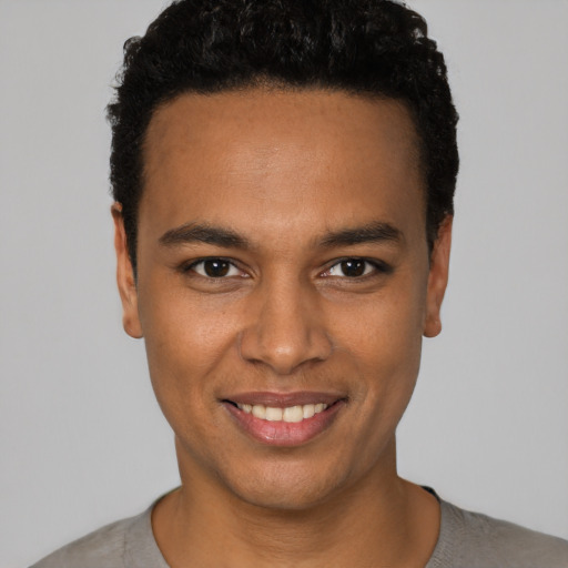 Joyful black young-adult male with short  black hair and brown eyes