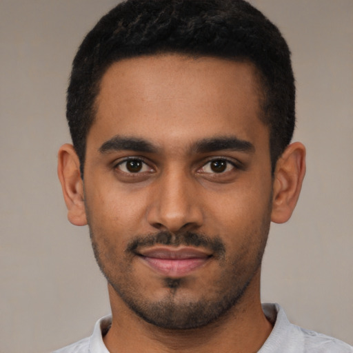 Joyful black young-adult male with short  black hair and brown eyes