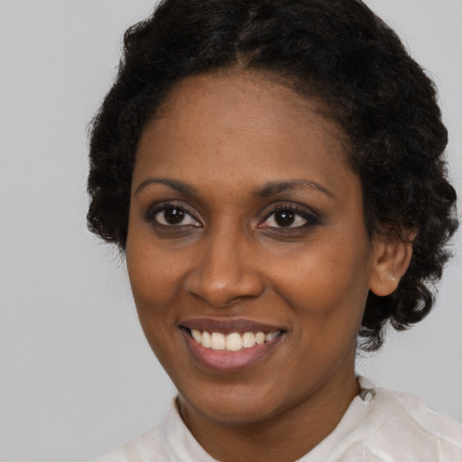 Joyful black adult female with medium  brown hair and brown eyes